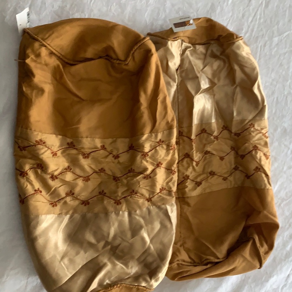 Two golden color pillows covers with red design